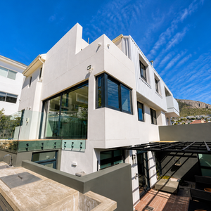 Modern white building renovation with large glass windows.