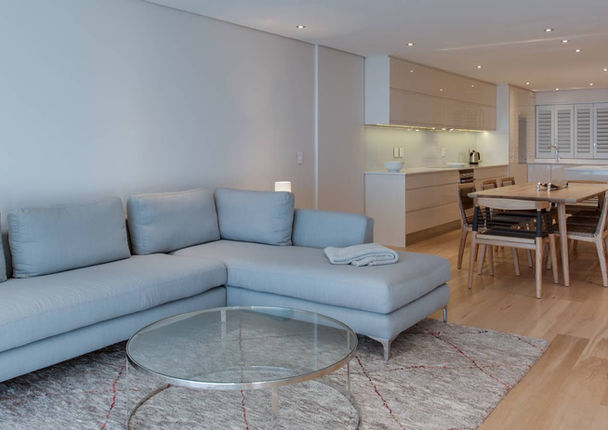 Modern living room with sectional sofa and glass table.