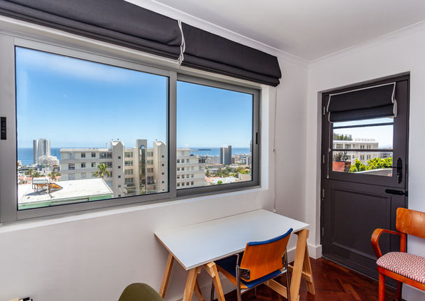 Room with desk, chair, and city view window.