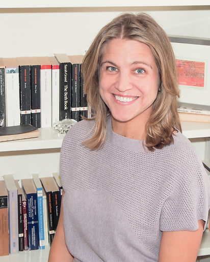 Portrait of Lauren Simek, PhD, academic editor and nonfiction writing coach, in front of bookshelf