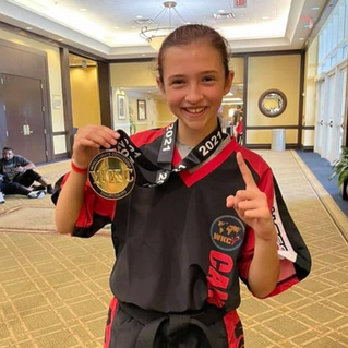 Team Capicio karate student posing with a gold medal.