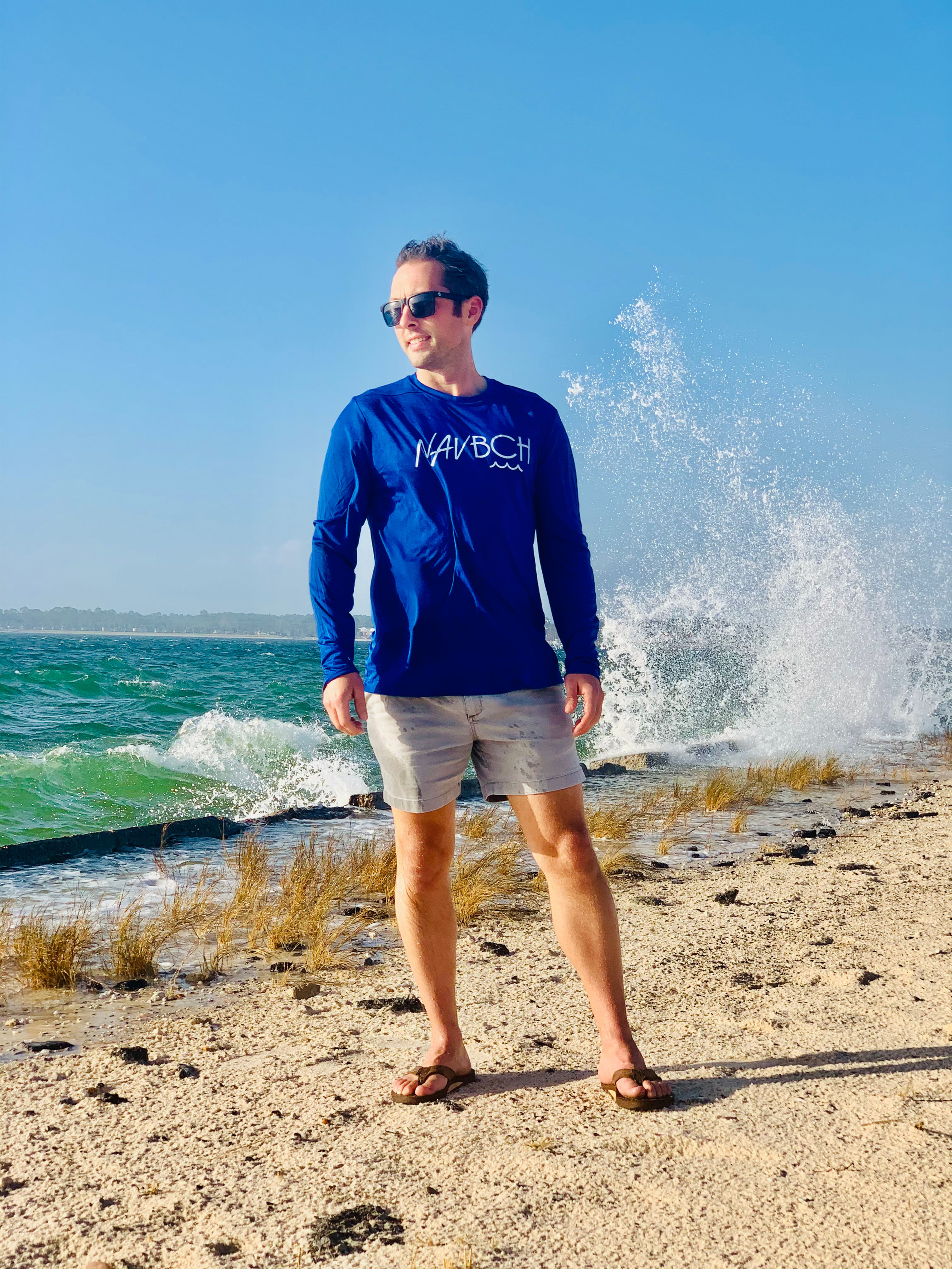 Man on Navarre Beach Causeway wearing Front view of NAV BCH Longsleeve Performance UV in Deep Sea Blue