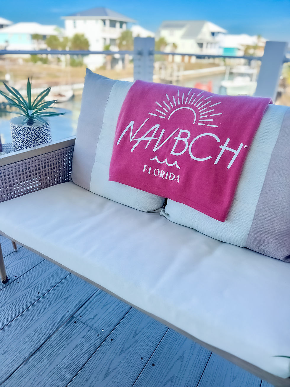 Thumbnail: Bright Coral color beach NAV BCH blanket in home on Navarre Beach