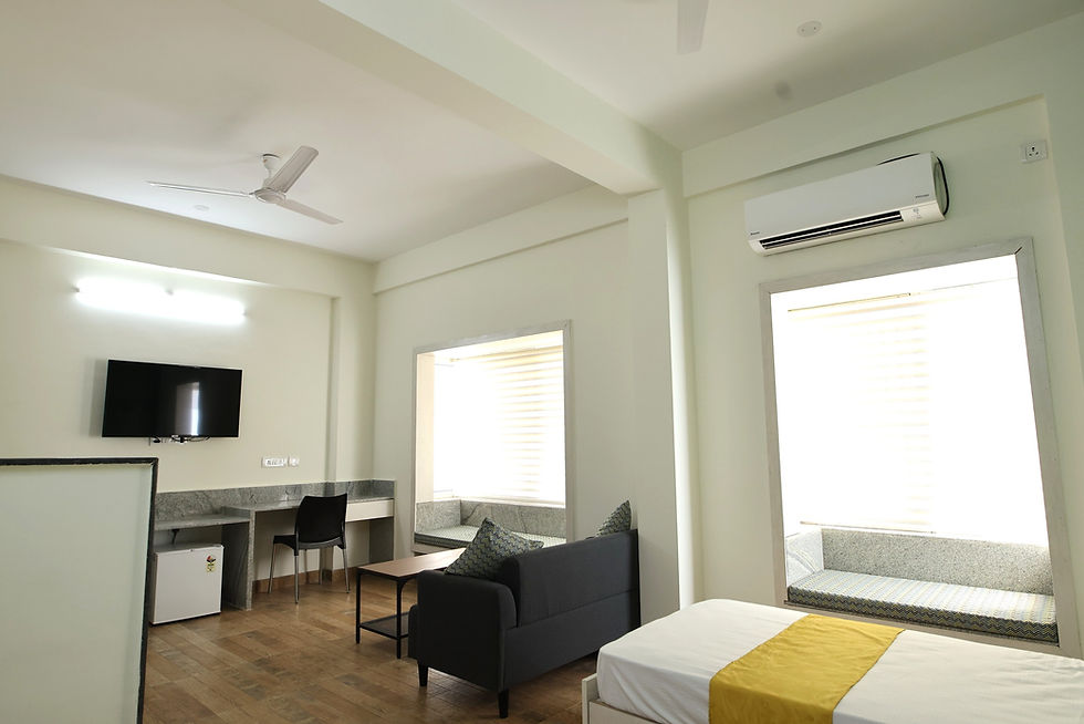 Eye-level view of a spacious, well-lit ladies PG room with modern furniture