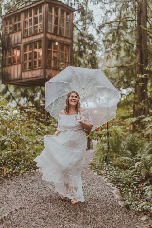 Treehouse point bride with umbrella laughing