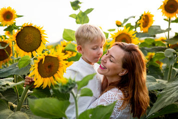 Napraforgók között fehér ruhában anya és fia