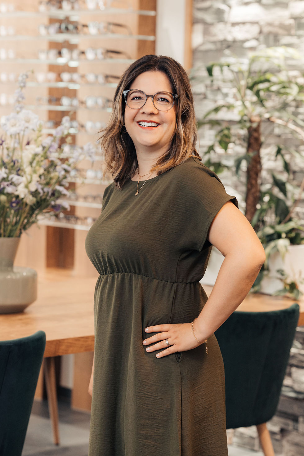 Portrait von Manuela Grossenbacher, im Hintergrund Brillen auf Holzgestellen