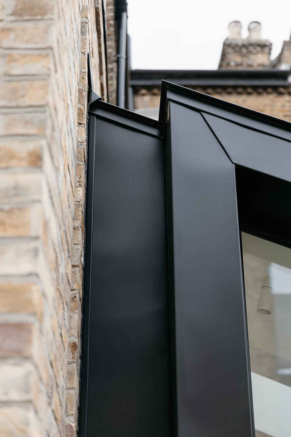 Close-up of a standing seam detail by Golden Triangle Architects, showcasing precise metal panel alignment and modern craftsmanship.
