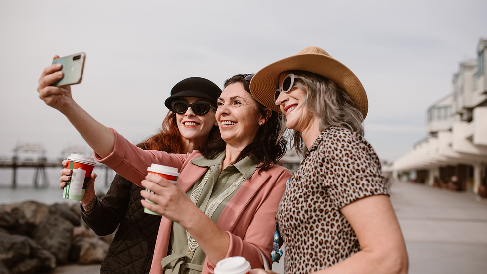 3 tolle Frauen, die am. Wasser stehen und ein Selfie machen