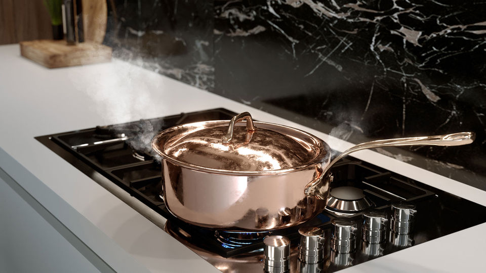 Copper pot steaming on modern gas stove