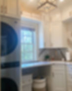 Modern laundry room with white cabinets and stacked washer dryer