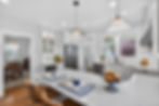 Modern white kitchen with marble island and pendant lights