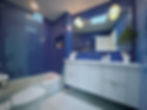 Modern bathroom with blue mosaic tiles and white vanity.