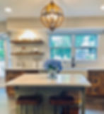 Modern kitchen island with bar stools and orb chandelier