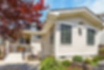 Beige cottage exterior with red maple tree and patio