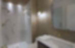 Modern bathroom with marble shower and gold fixtures