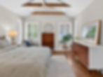 Modern bedroom with vaulted ceiling, wood beams, and mid-century furniture