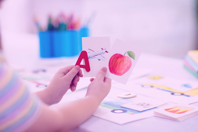 Child holding flashcards