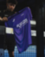 Player holding a tournament jersey.