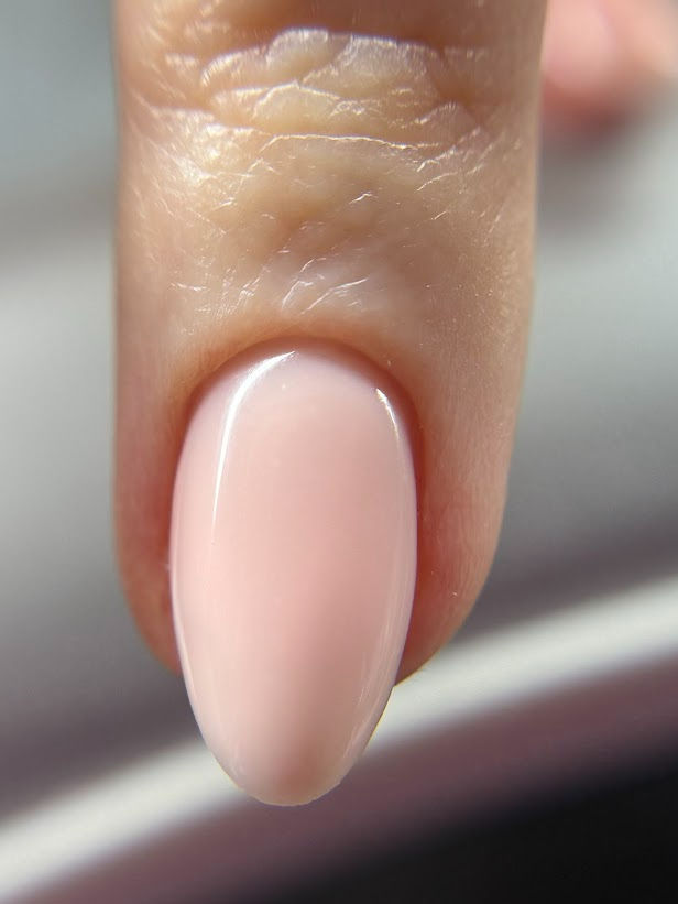 Close-up view of a neatly shaped nail with a glossy finish