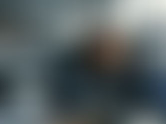 Woman in an office appears concerned while reading news on "AI-Driven Automation" at her computer, with colleagues discussing in the background. Is their jobs next.