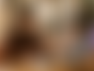 A parent and child sit together at a kitchen table mid-conversation, a book and baseball nearby, in a warm home learning moment.