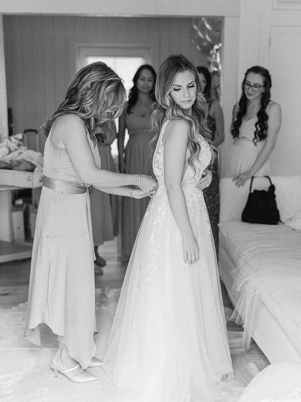 bride mom zipping up her wedding dress
