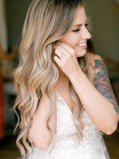 bride putting on her earrings