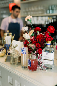 red and white flowers with drinks in front of them for an austin event at the wayback
