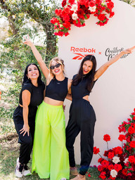 girls posing in front of a sign for an Austin event at the wayback for International Women's Day