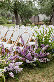 tented wedding ceremony outside at the wayback with bright colorful flowers surrounding the aisle and the altar