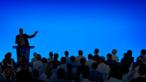 corporate-businessman-giving-presentation-large-audience.jpeg