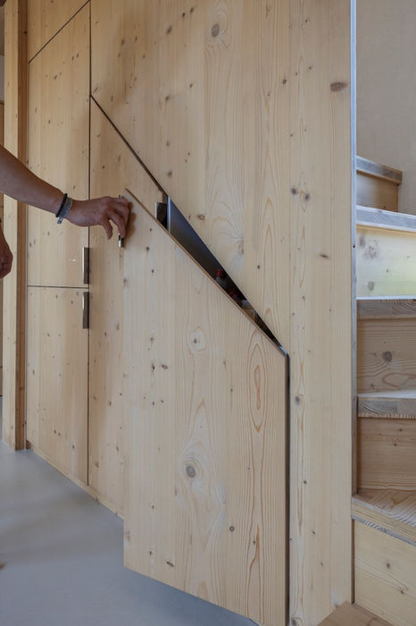 Detail van een verborgen opbergvak in de massief houten kastenwand van Indigo, naast de houten trap.