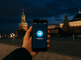 Smartphone showing the Telegram messaging app with the Moscow Kremlin in the background, illustrating Russia's charges against founder Pavel Durov.