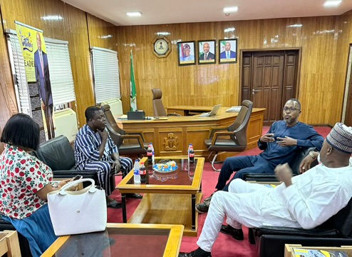 Dr. Oludare Ogunlana in discussion with NBTI Director General Dr. Kazeem Kolawole Raji during a courtesy visit at the agency's office in the Federal Secretariat, Abuja, with the Nigerian coat of arms and official portraits visible in the background