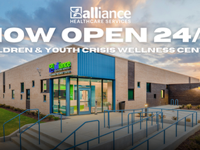 Alliance Healthcare Services building at sunset with sign Now Open 24/7 Children & Youth Crisis Wellness Center.