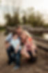young family smiling by fence