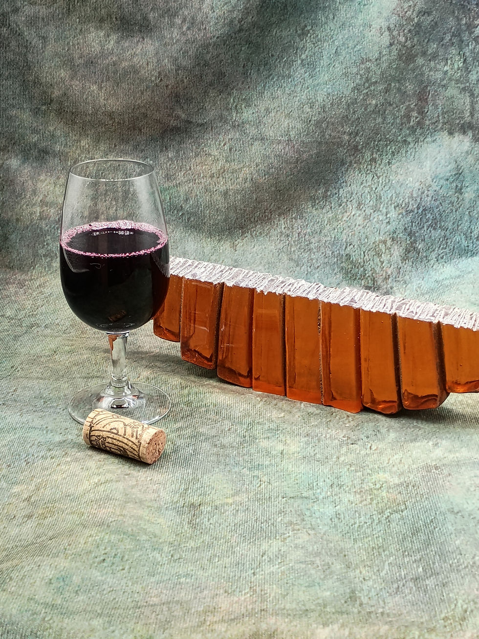 View of Amber Divide glass sculpture displayed with wine glass and cork