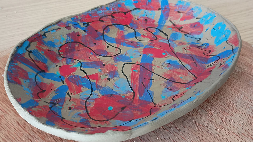 Hand-built ceramic bowl with red, blue and black mono-print pattern made using underglaze transfer technique.