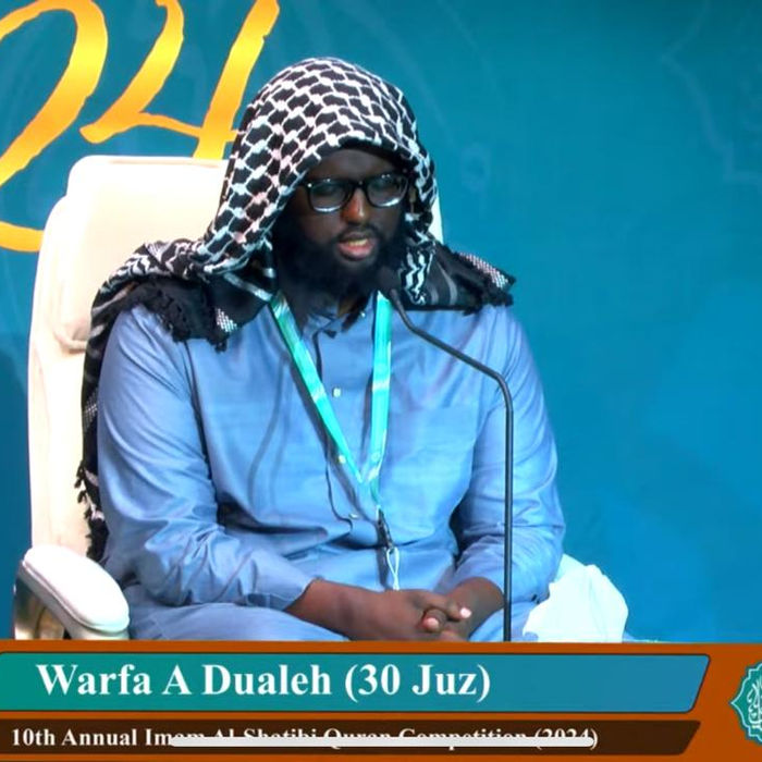Warfa A Dualeh (30 Juz) speaking on stage at Dar Al Quran in 2024.
