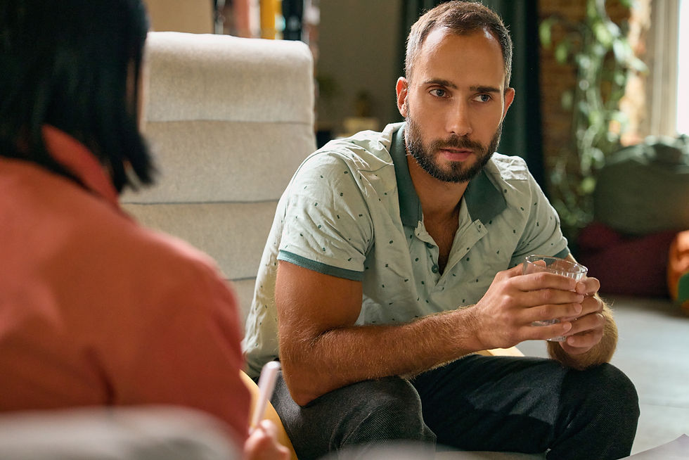Men in therapy sitting with a glass of water in his hand