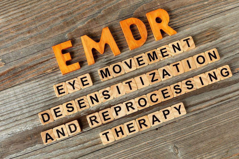 Wooden letter tiles spelling EMDR eye movement desensitization and reprocessing on weathered wood background.