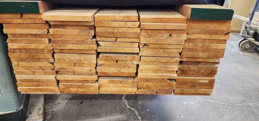 Stacked hardwood lumber acclimating in cabinet shop