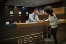 Concierge assisting international patient with check-in as part of Willenhall Group’s coordinated medical travel support, ensuring smooth arrival and accommodation for treatment in the UK.