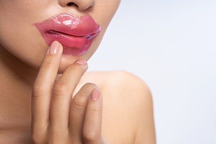 Close up of beautiful female using lip p