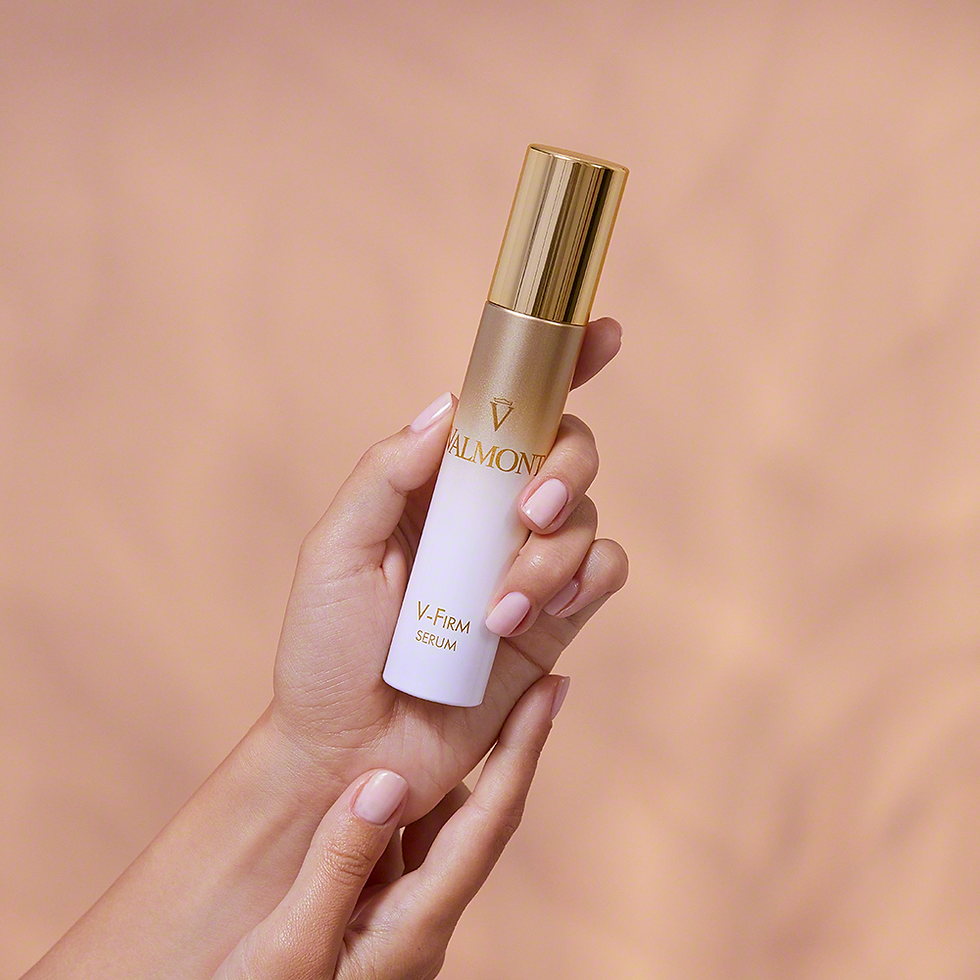Thumbnail: Hand holding Valmont V-Firm Serum bottle against light background