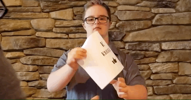 Young man holding a page upside down