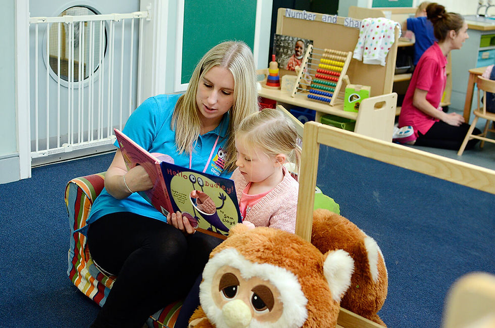 Nursery lady sat with little girl reading