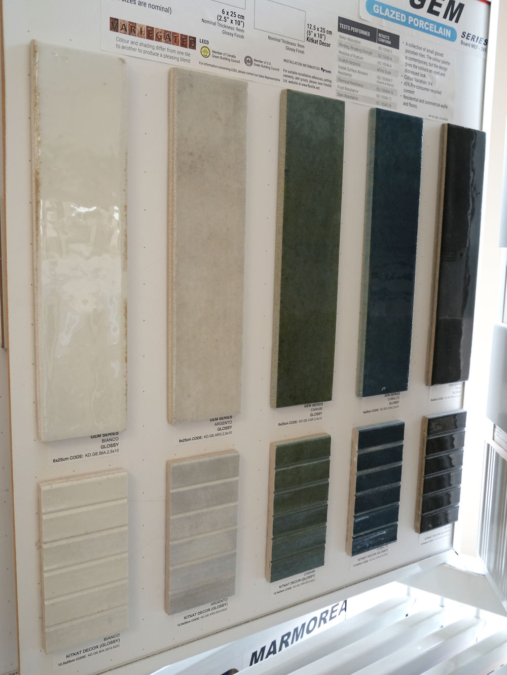 Display of vertical backsplash tile samples in various colors and textures