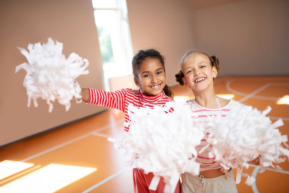 Best friends smiling. Best friends smiling while practicing cheerleading together at schoo